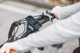 Close-up of a rider’s gloved hand gripping the handlebar with detailed gear visible.