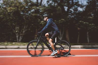 A dynamic shot of a cyclist in motion wearing a lightweight, breathable jacket with reflective accents.