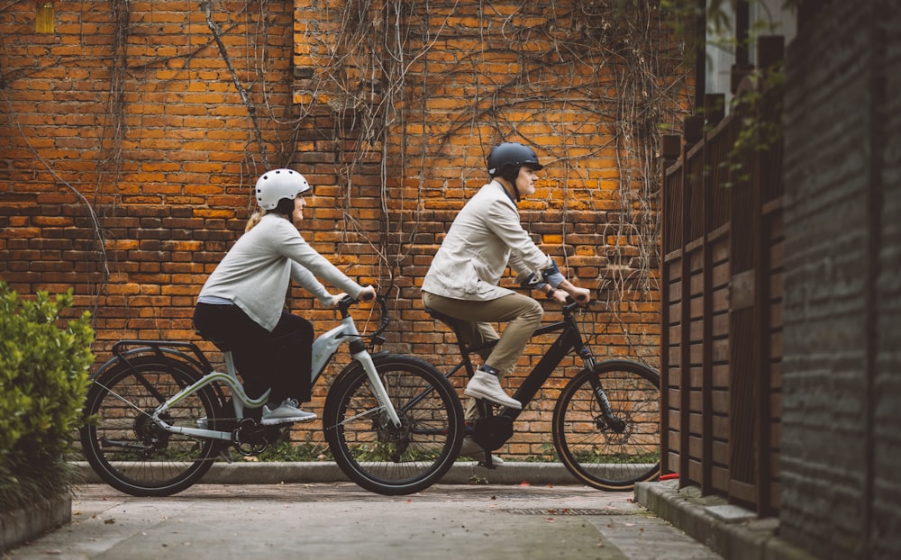 a couple of people riding bikes down a street