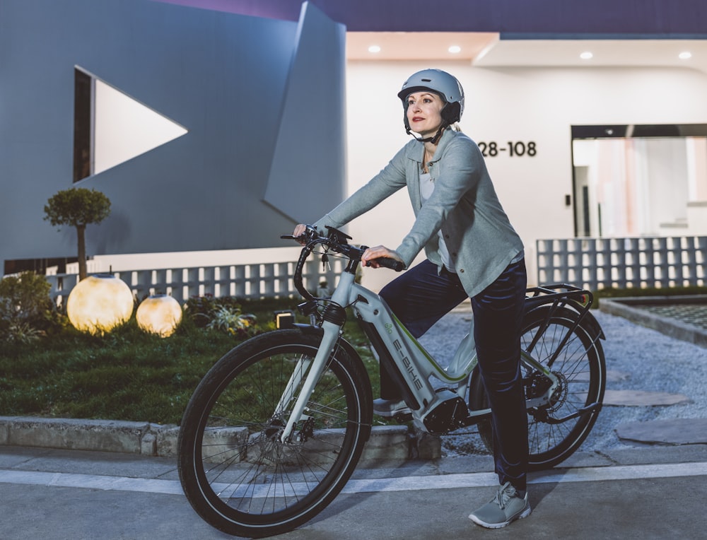 a woman riding a bike in front of a building