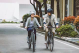 a couple of people riding bikes down a street