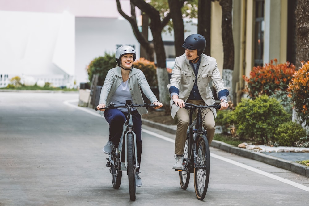 a couple of people riding bikes down a street