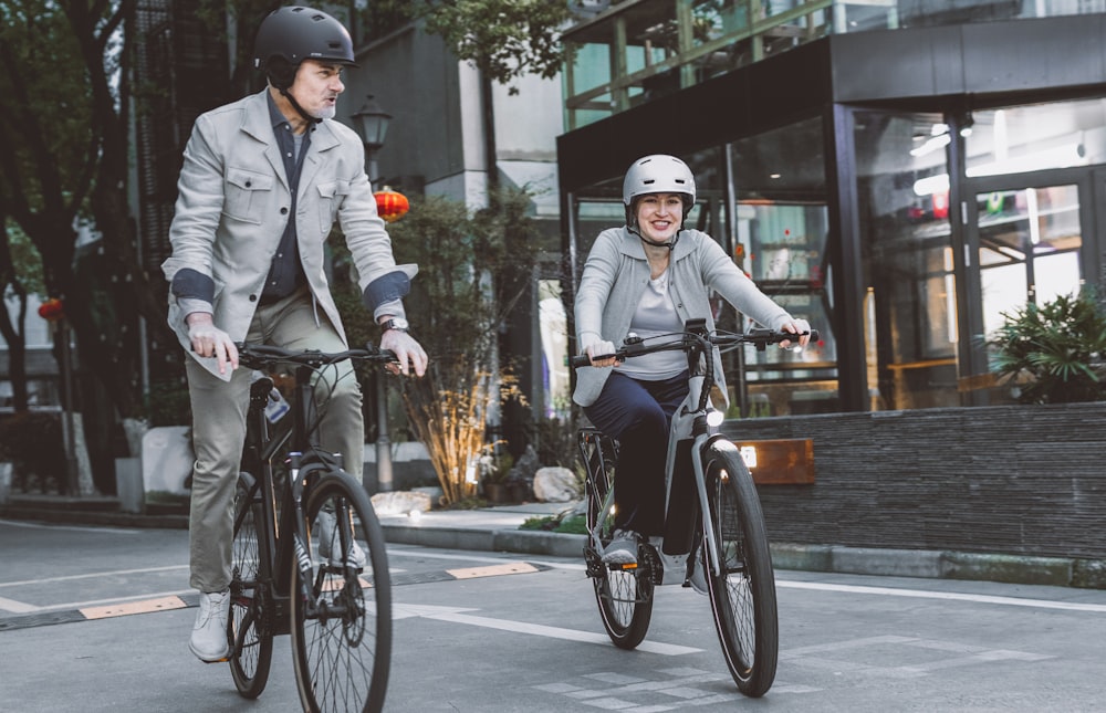 a man and a woman riding bikes down a street