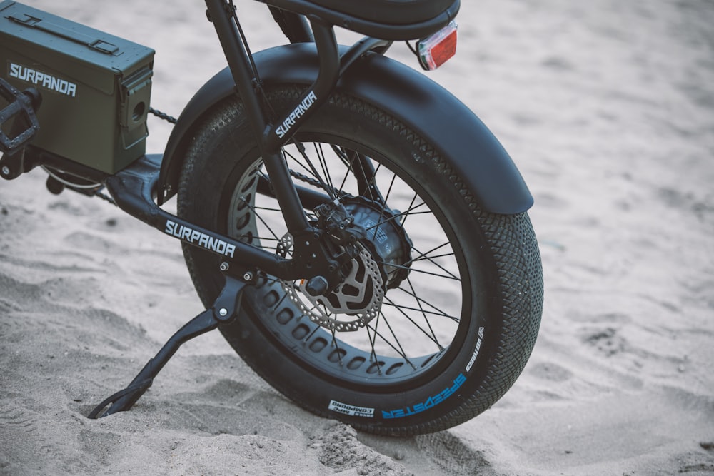 a close up of a motorcycle parked in the sand
