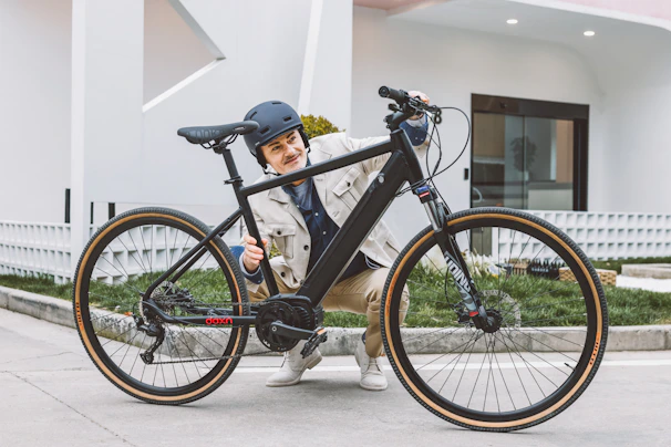A smiling woman adjusting her helmet next to her racing bike.