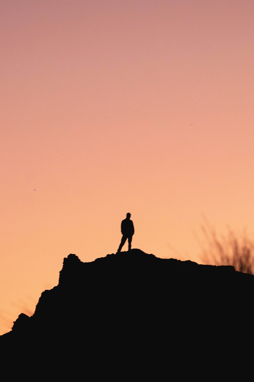 a person standing on top of a hill at sunset