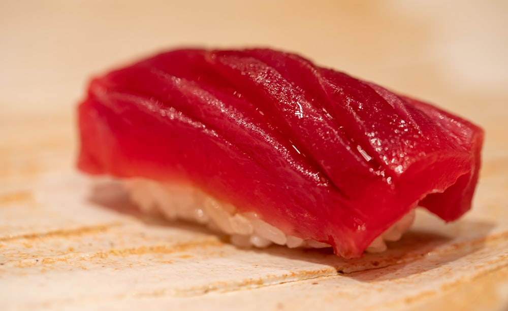 a piece of sushi sitting on top of a wooden table