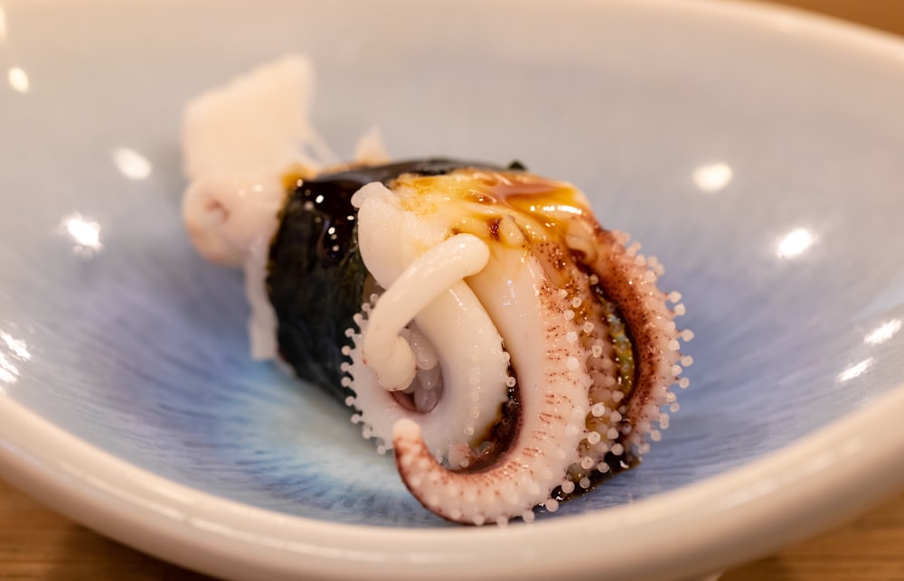 an octopus sushi is on a blue plate