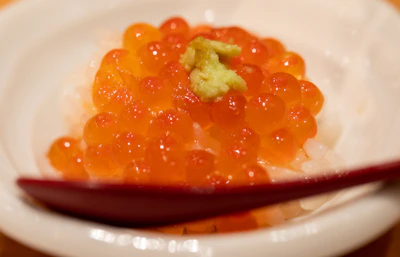 Close-up of golden mullet roe slices with olive oil drizzle and fresh bread.