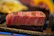 Close-up of a perfectly grilled Wagyu steak with rich marbling and a smoky char crust.