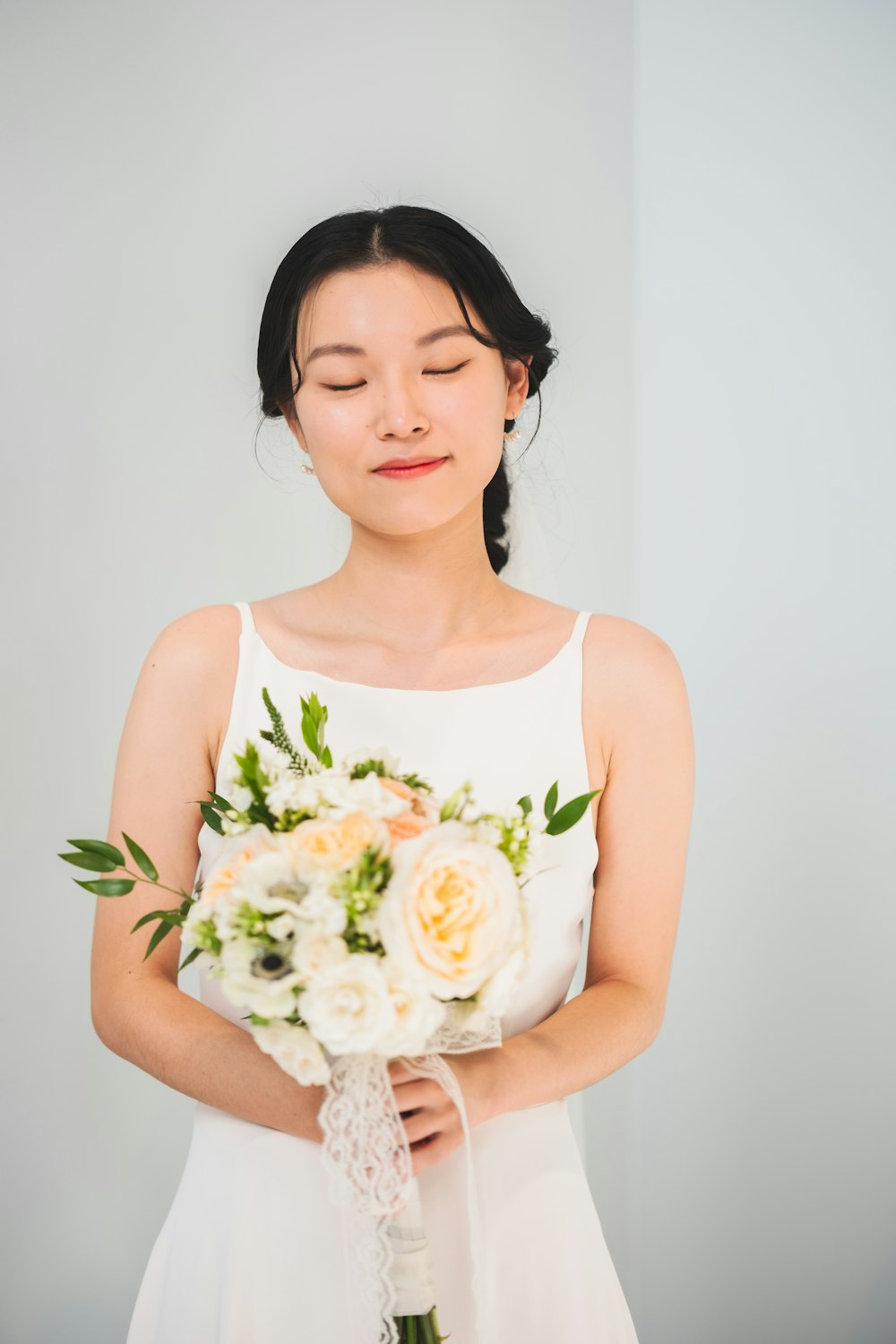 a woman in a white dress holding a bouquet of flowers