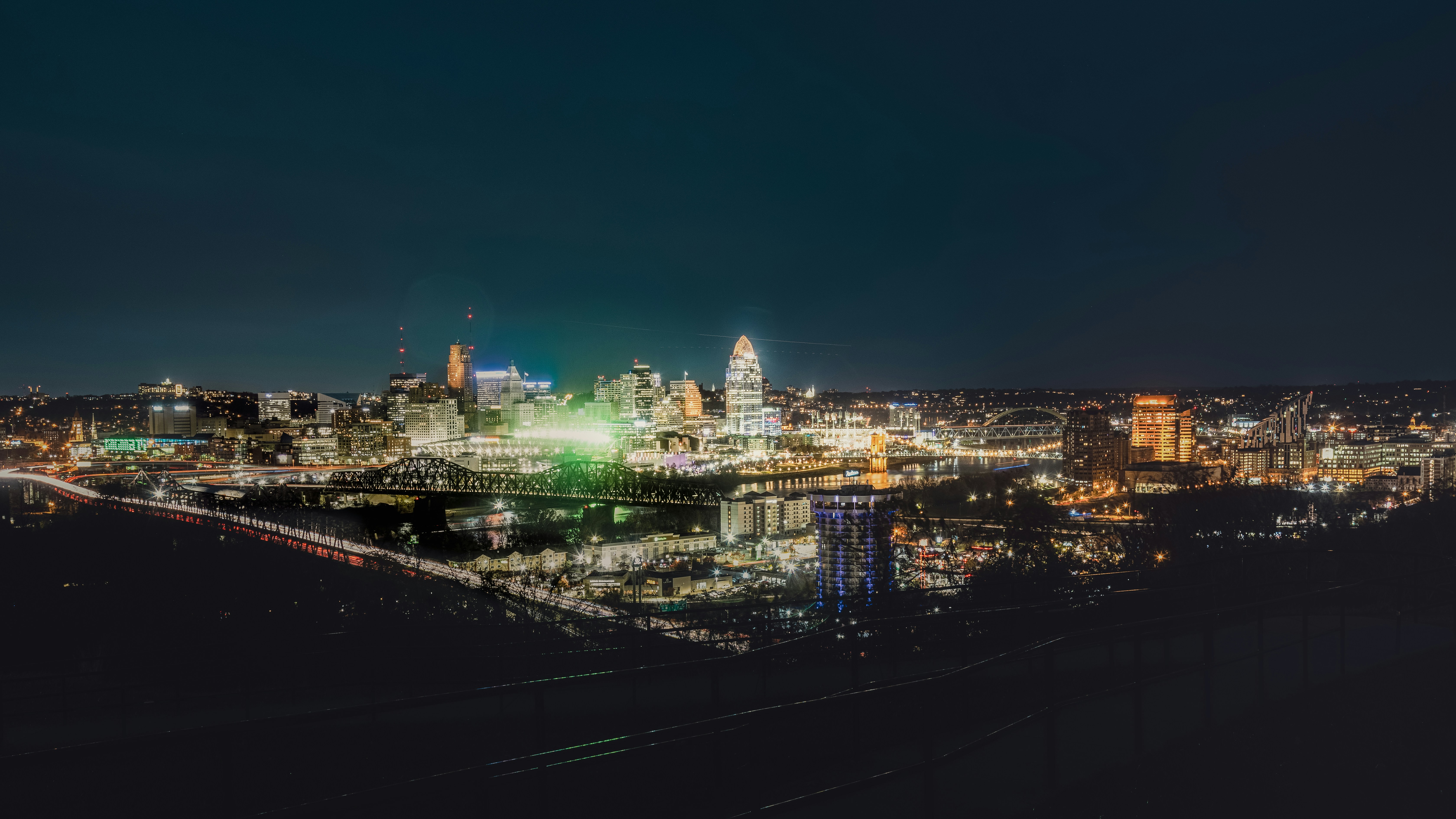 a view of a city at night with a bridge in the foreground