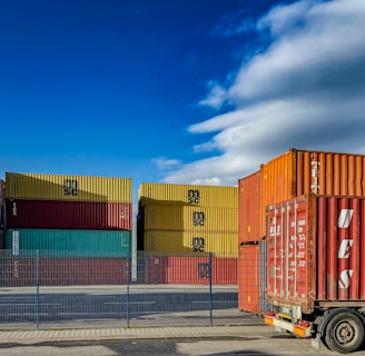 a truck is parked in front of a bunch of shipping containers