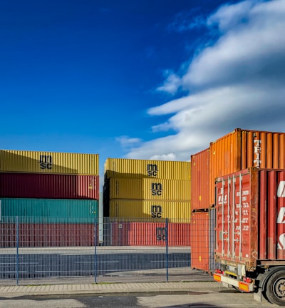 a truck is parked in front of a bunch of shipping containers