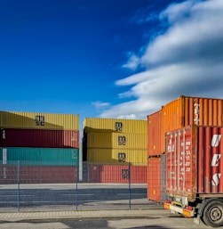 a truck is parked in front of a bunch of shipping containers