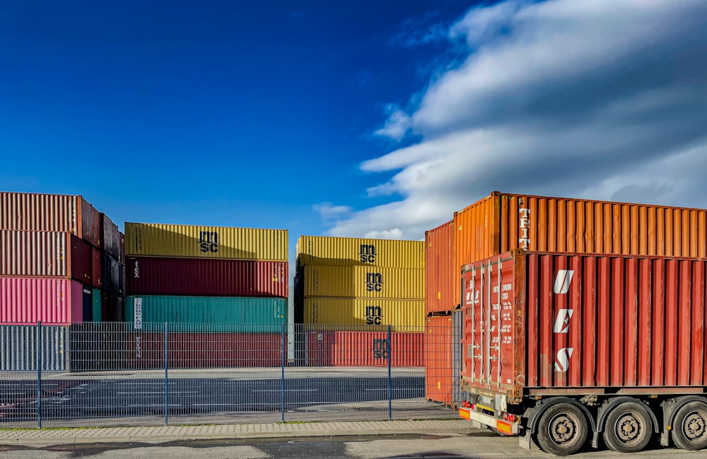 a truck is parked in front of a bunch of shipping containers