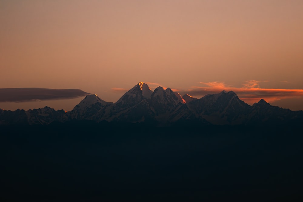 uma vista de uma cordilheira ao pôr do sol