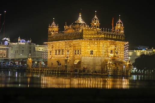 The temple illuminated by lamps during the colorful evening pooja ceremony.