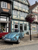 A classic convertible parked by a charming European village street.
