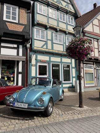 A classic convertible parked by a charming European village street.