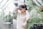 a woman standing in a greenhouse holding her hair