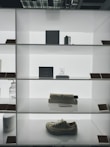 Stylish modern shoes displayed on a minimalist shelf with natural light