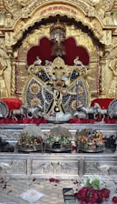 A vibrant red and black themed altar dedicated to Ogum with candles and offerings.