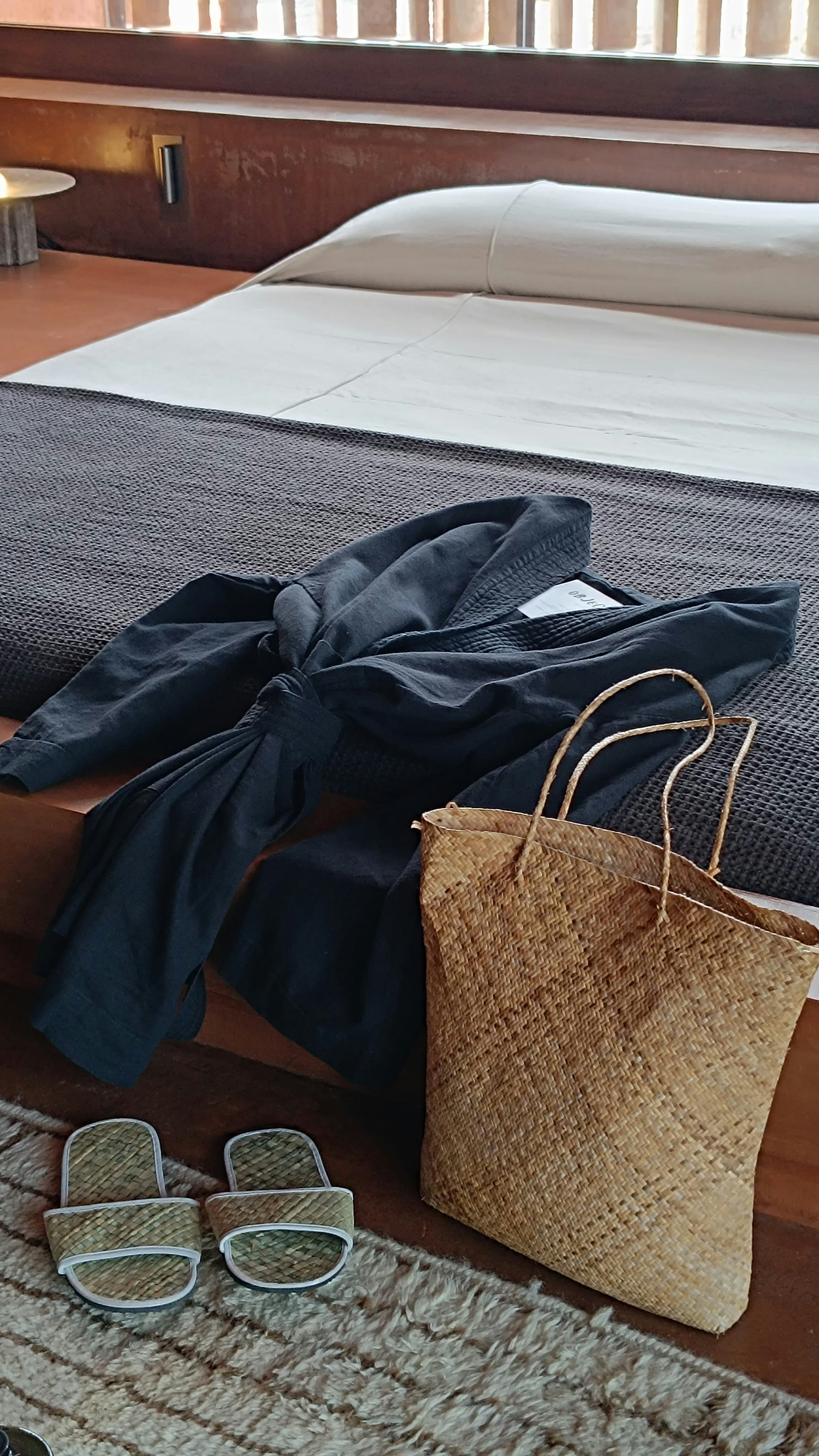 uma cama com um saco e alguns óculos de sol sobre ele