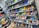 A display of various colorful athletic shoes neatly arranged on multiple shelves. The shoes come in a variety of designs and colors, including neon greens, blues, oranges, and vibrant patterns.
