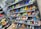 A display of various colorful athletic shoes neatly arranged on multiple shelves. The shoes come in a variety of designs and colors, including neon greens, blues, oranges, and vibrant patterns.