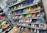 A display of various colorful athletic shoes neatly arranged on multiple shelves. The shoes come in a variety of designs and colors, including neon greens, blues, oranges, and vibrant patterns.