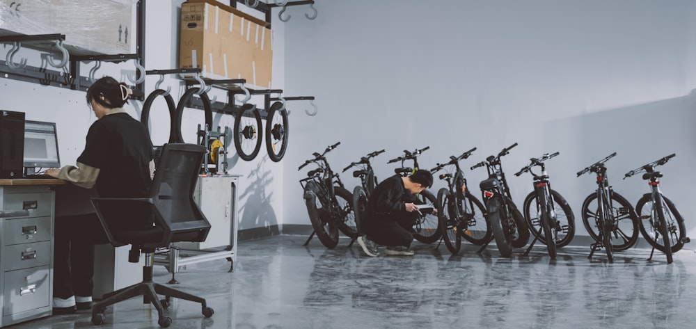 a woman sitting in front of a row of bikes