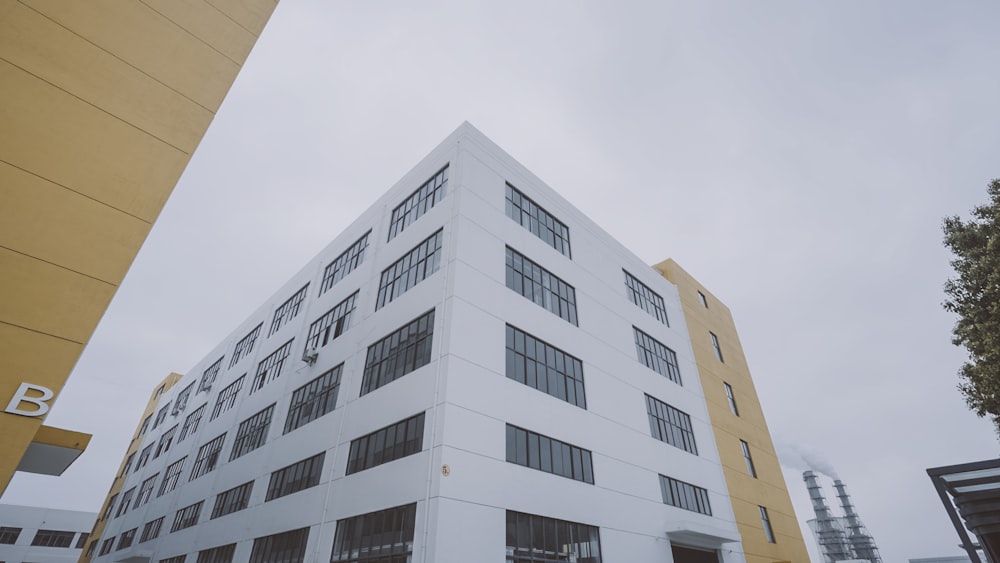 a tall white building sitting next to a tall yellow building