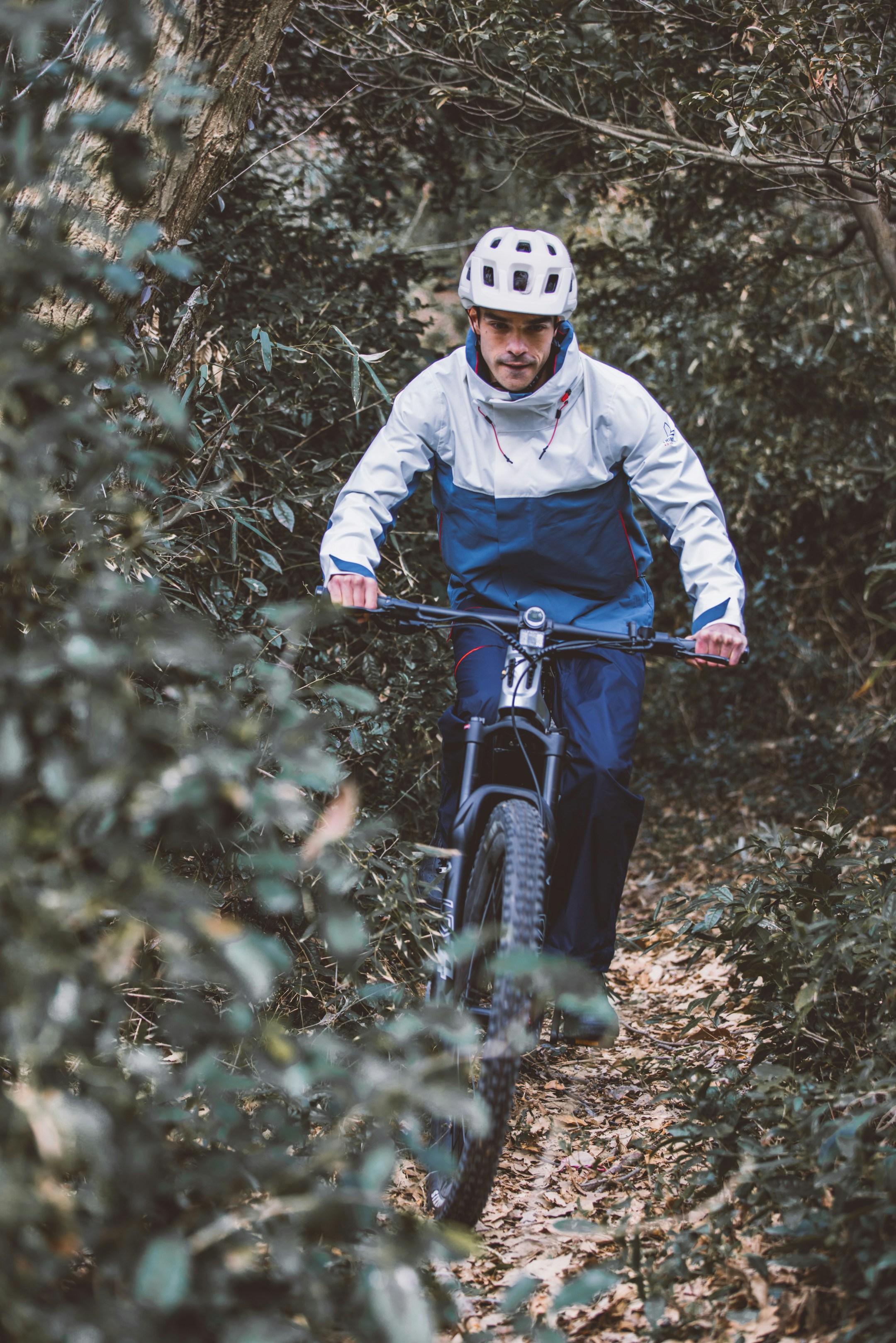 a man riding a bike through a forest