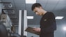 a man standing in a room holding a clipboard