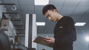 a man standing in a room holding a clipboard