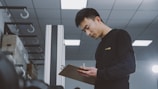 a man standing in a room holding a clipboard