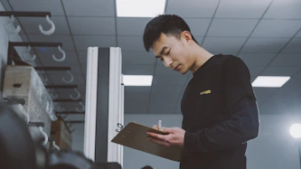 a man standing in a room holding a clipboard