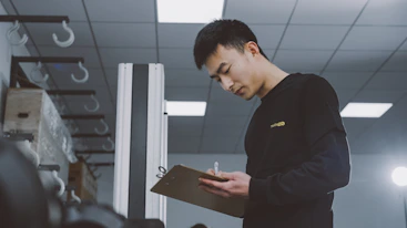 a man standing in a room holding a clipboard