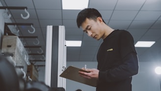 a man standing in a room holding a clipboard