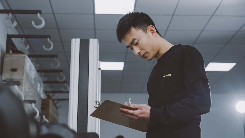 a man standing in a room holding a clipboard