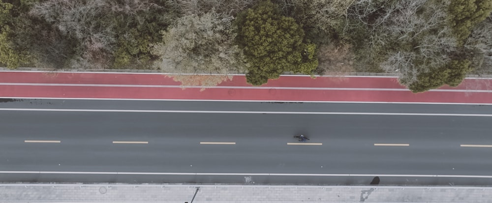 an aerial view of a street with a car driving on it