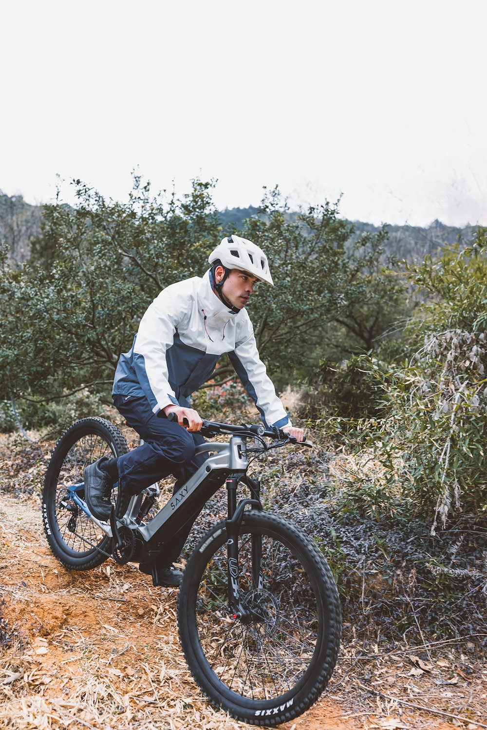 a man riding a bike down a dirt road