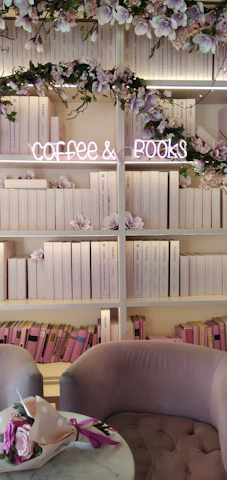 A bright, inviting reading area with modern seating, soft lighting, and a small counter serving tea and coffee.