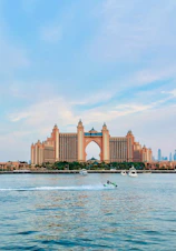 a boat is in the water in front of a large building