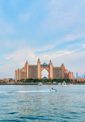 a boat is in the water in front of a large building