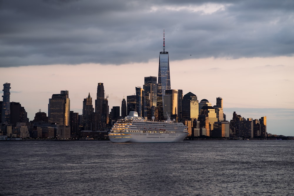 a large cruise ship in front of a city skyline
