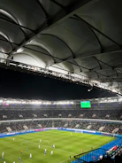 Close-up of a football contract being signed under stadium lights.
