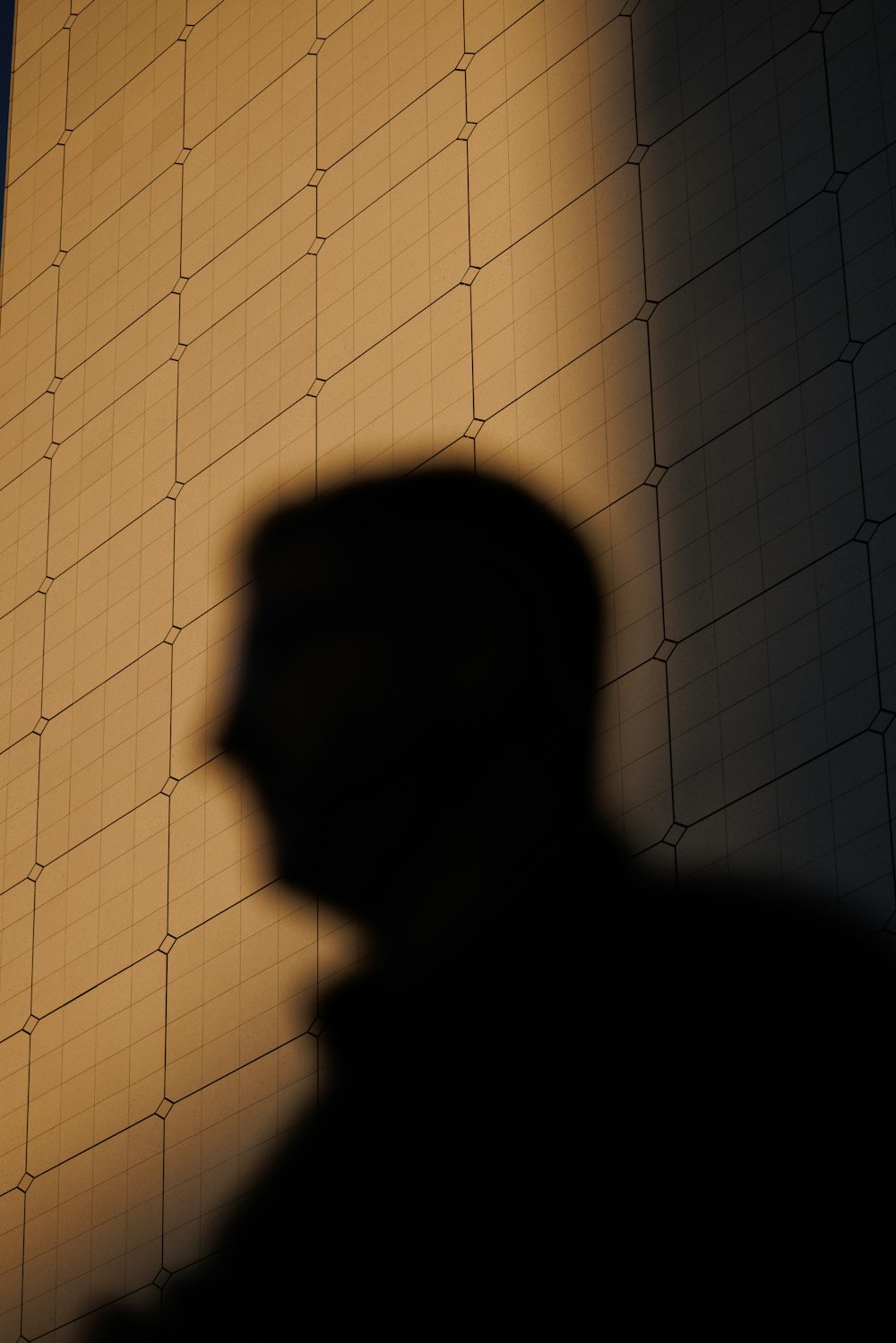 a man standing in front of a wall with a clock on it