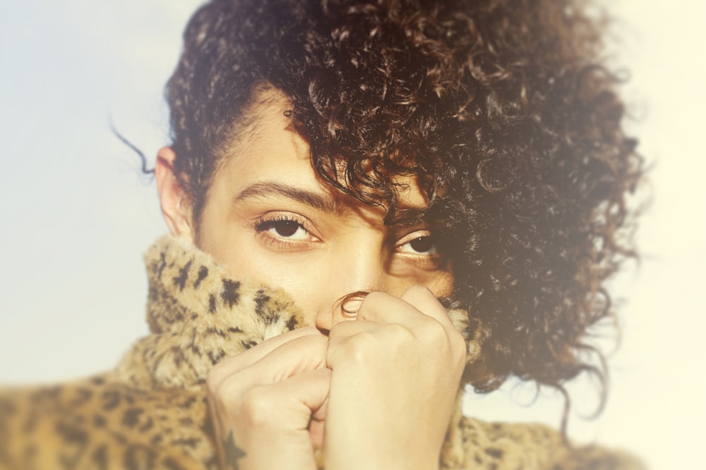 a close up of a person wearing a leopard coat